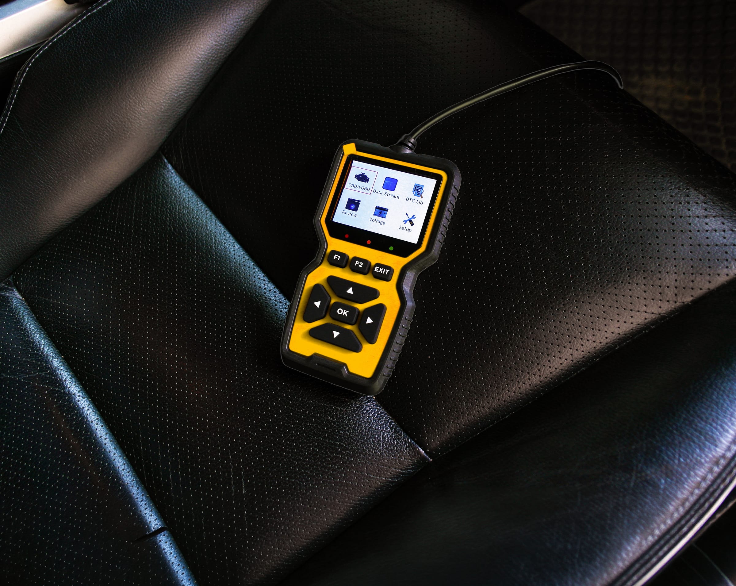 OBD-Diagnosegerät auf einem Autositz mit Diagnose-Menü auf dem Display