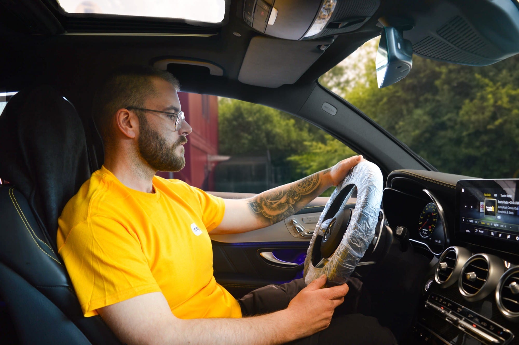 cenya. driver at the wheel of the collected customer car on the way to the workshop